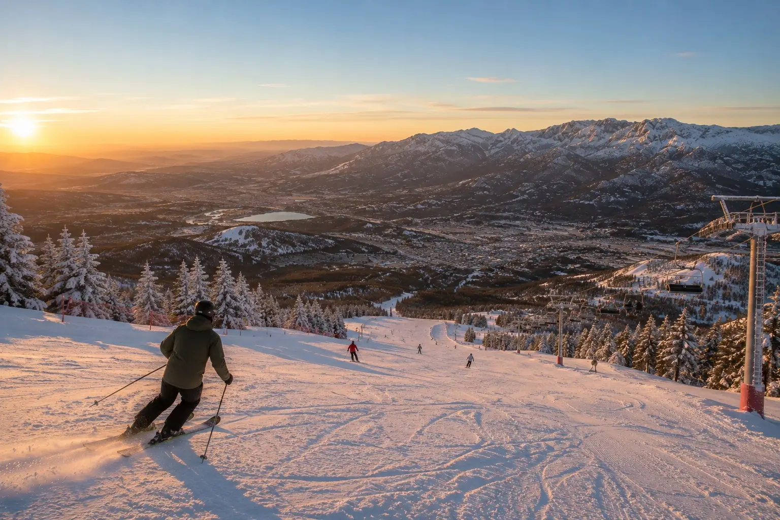 Skiing above the valley at sunset, the reservoir and villages far below